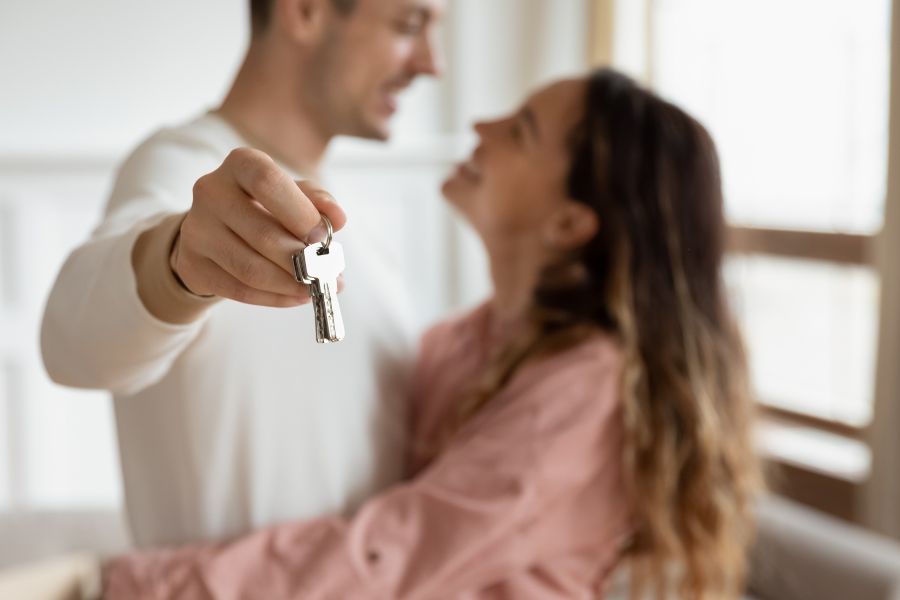 pareja feliz mostrando llaves de una vivienda
